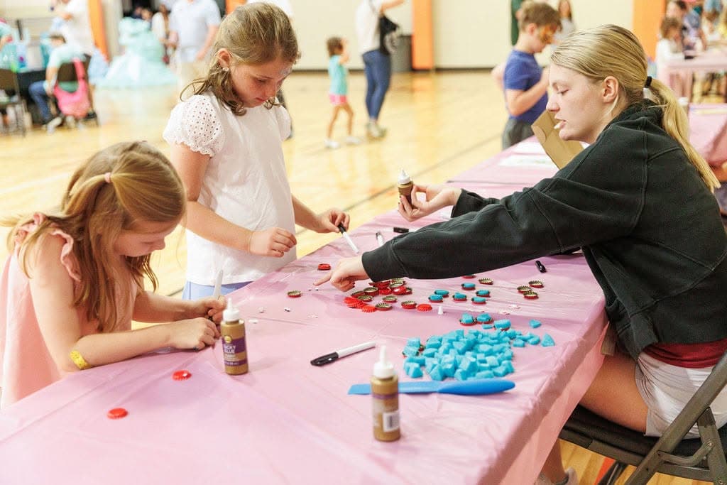 Children making crafts together at tables at a St. Mary’s event