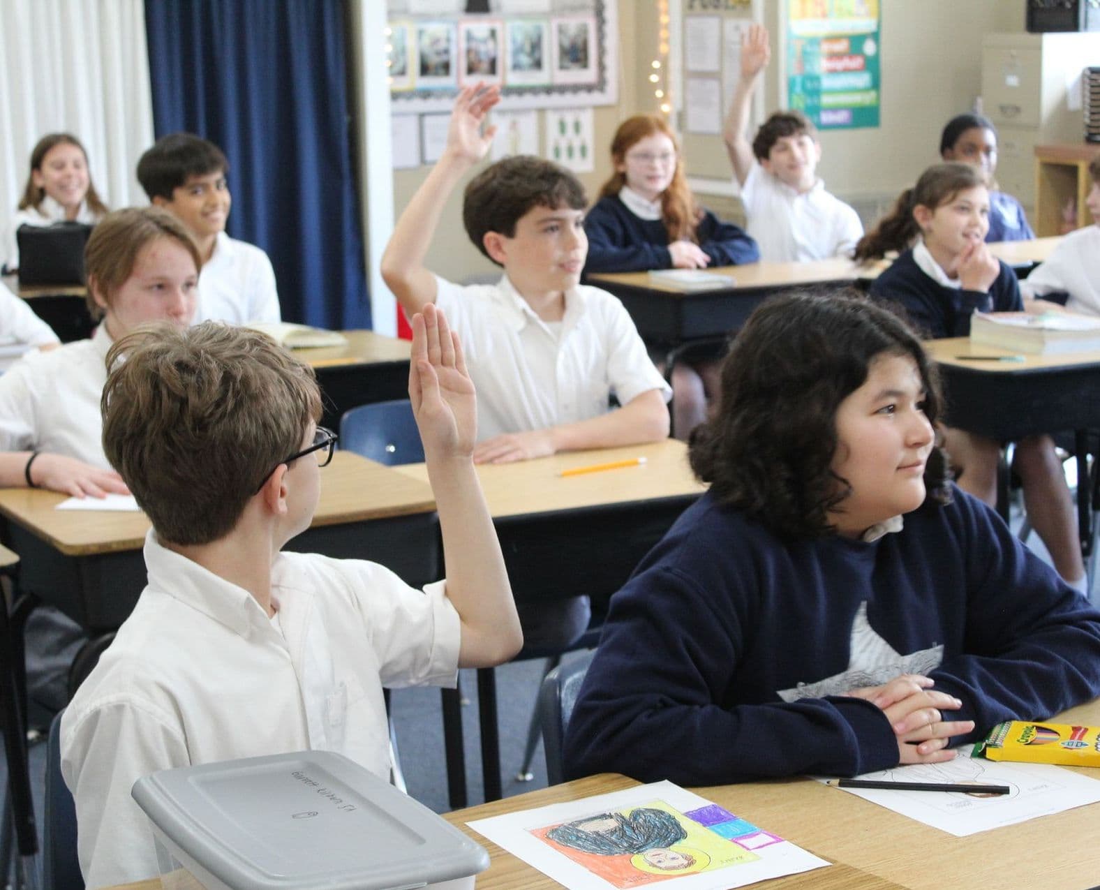 St. Mary’s Catholic School students raising their hands in a classroom